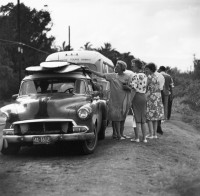 Sunset Beach Tourists, Women Looking at Surfboards on Car, 1963